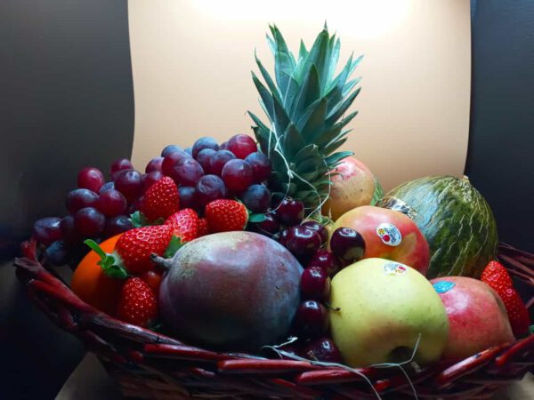 Cesta de mimbre envuelta con adorno navideno - frutas variadas